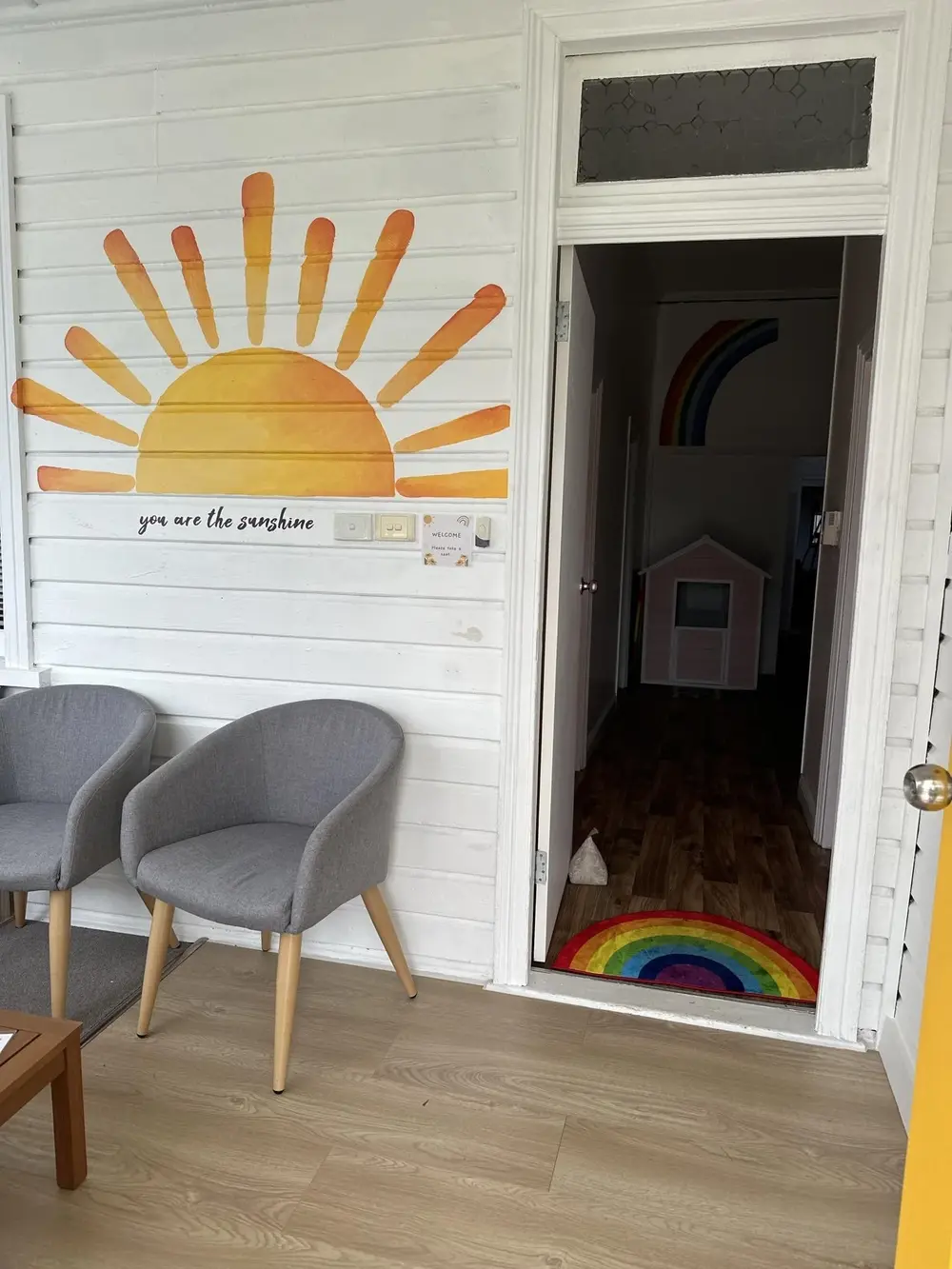 The welcoming entrance to a Sunshine therapy room, painted with a large yellow sun